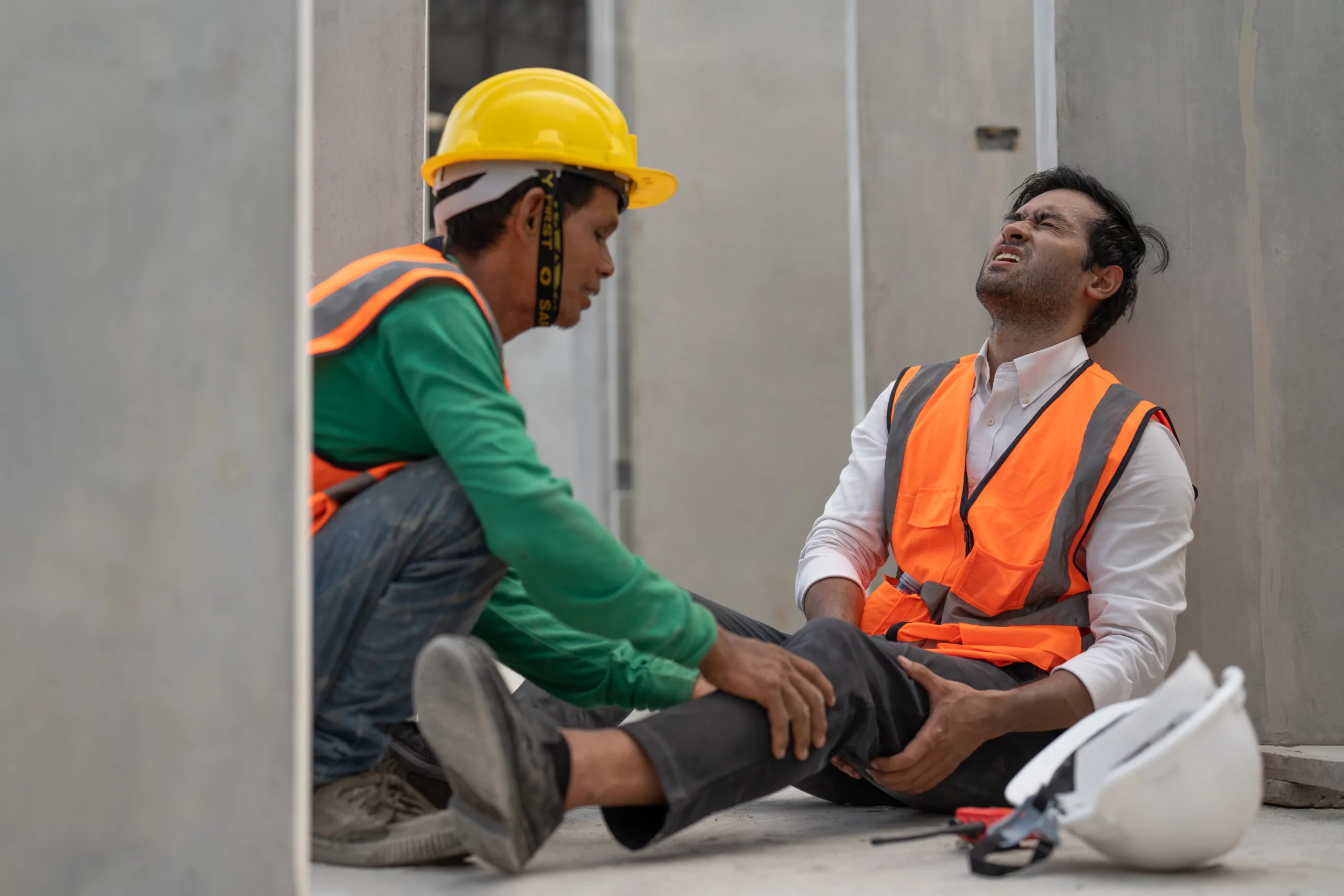 Construction worker assisting injured coworker after job-site accident, illustrating Missouri workplace injury reporting.
